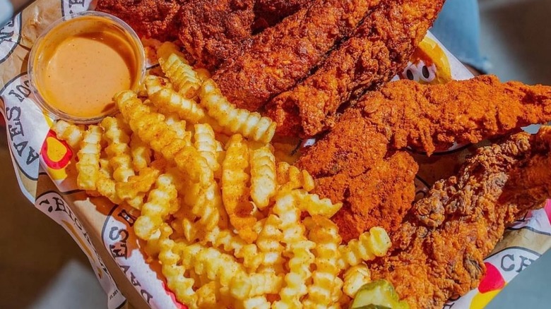 Dave's Hot Chicken displays a platter of chicken with fries.