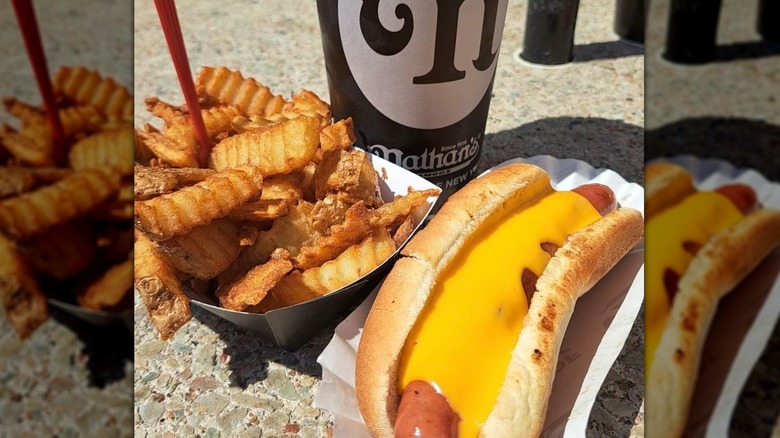 Nathan's Famous hot dog, drink, and fries sit on a table.