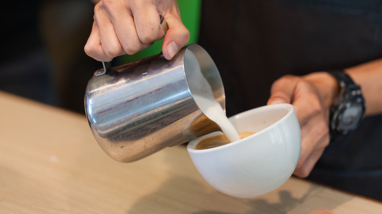 Starbucks worker making a latte