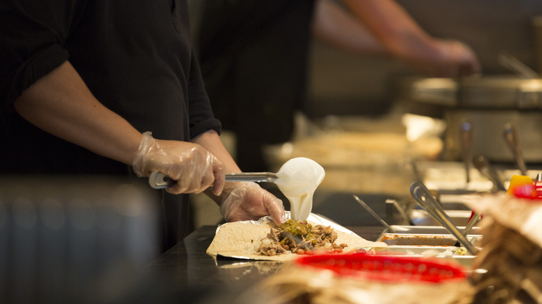 woman making burrito at Chipotle