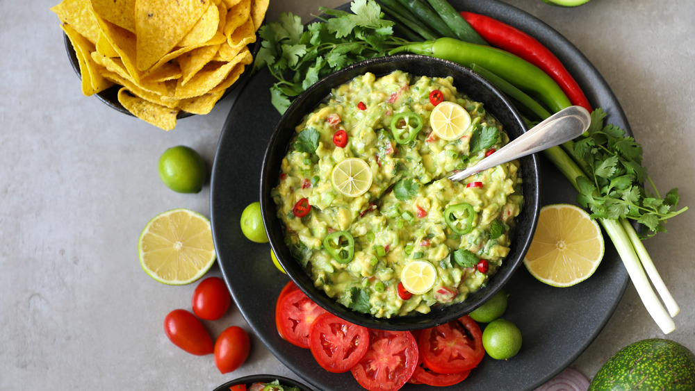 Black bowl of guacamole with citrus