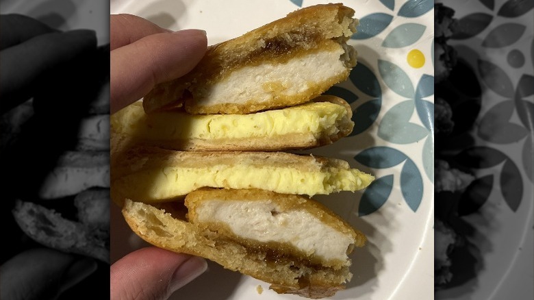 Hand holding half-eaten Starbucks sandwich