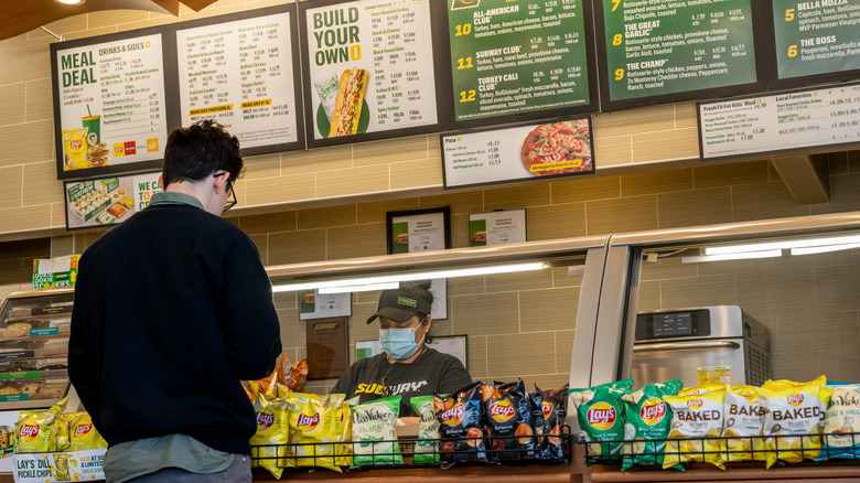 customer standing at Subway counter