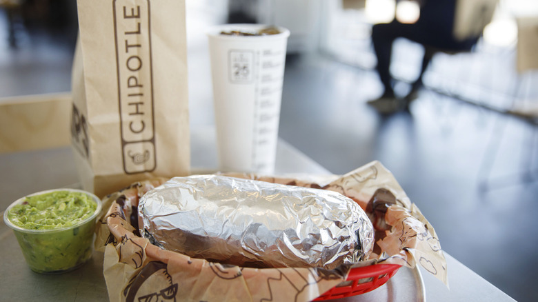 Chipotle burrito with drink and guacamole