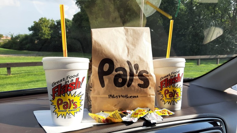 Pal's takeout bag and drinks on a car dashboard