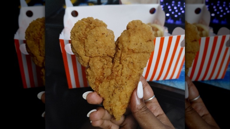 Hand holding heart-shaped chicken tender