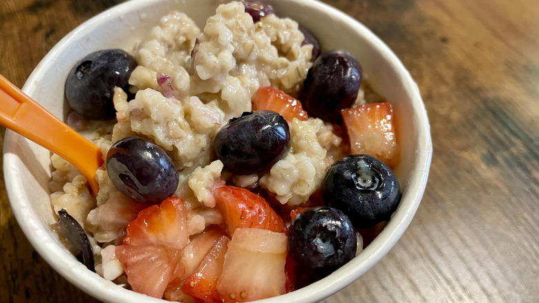 A cup of Jamba Make Your Own Oatmeal with blueberries, strawberries, and agave syrup