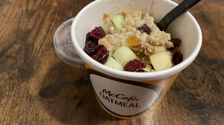 A cup of McDonald's Fruit & Maple Oatmeal with fresh diced apples, dried cranberries, and raisins