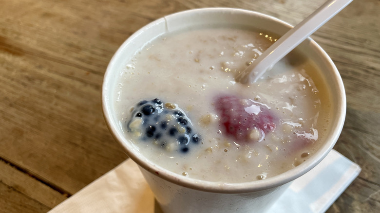 A cup of Le Pain Quotidien oatmeal with berries