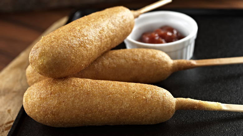 Three corn dogs on plate