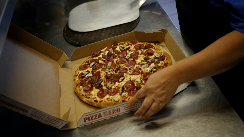 Domino's worker preparing pizza