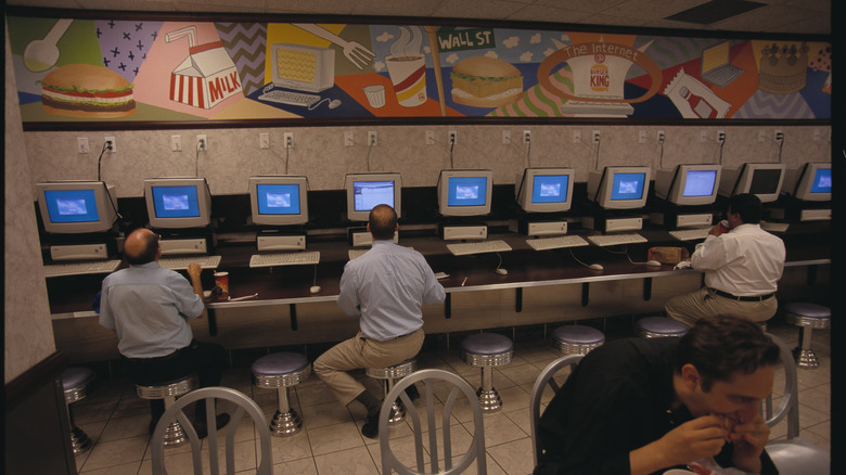 Men on computers under Burger King mural