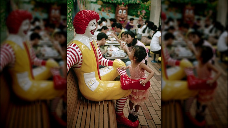 Plastic Ronald McDonald statue and child