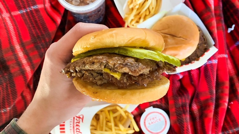 A customer holding a Freddy's steakburger