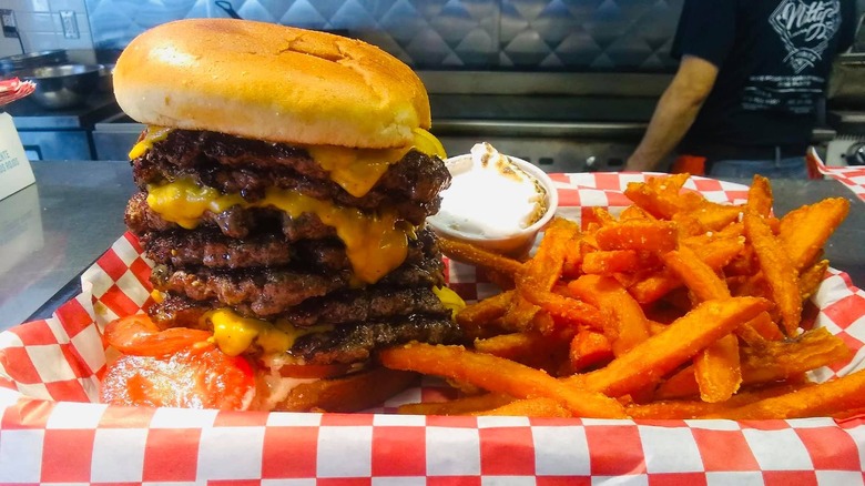 A closeup of a stacked Matty' G's Steakburger with sweet potato fries