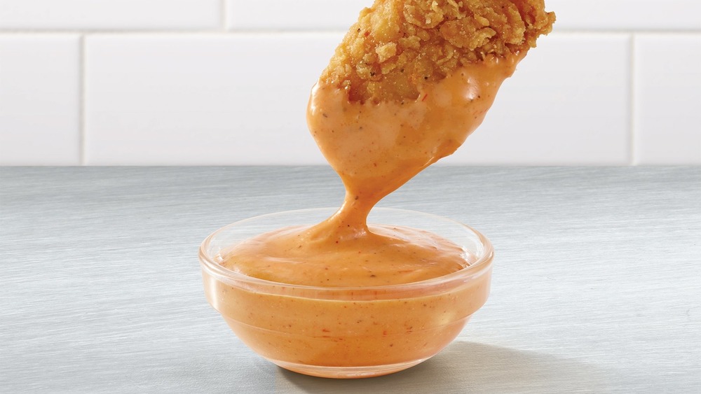 Wendy's chicken finger dipping into sauce