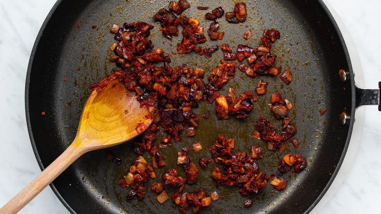 onion and wooden spoon in pan