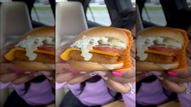 woman holding filet-o-fish BLT