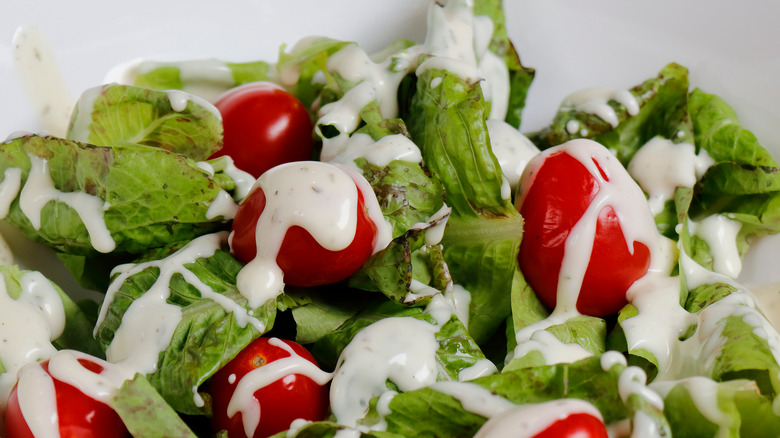 a healthy green salad dressed with ranch