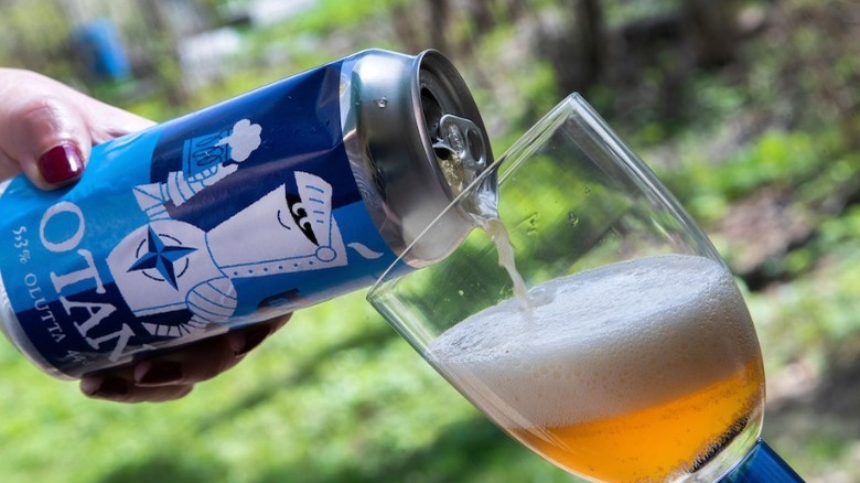 A can of OTAN beer being poured into a glass