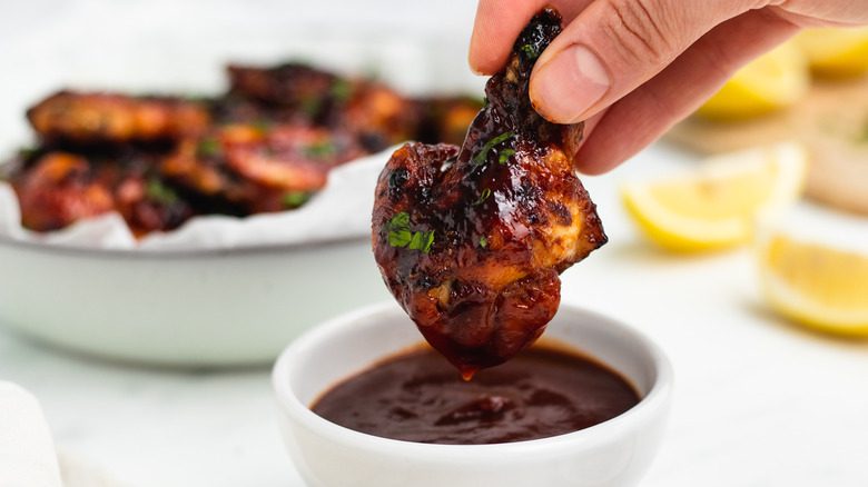 dipping chicken wing in sauce