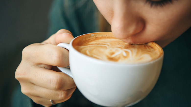 A woman taking a sip of coffee