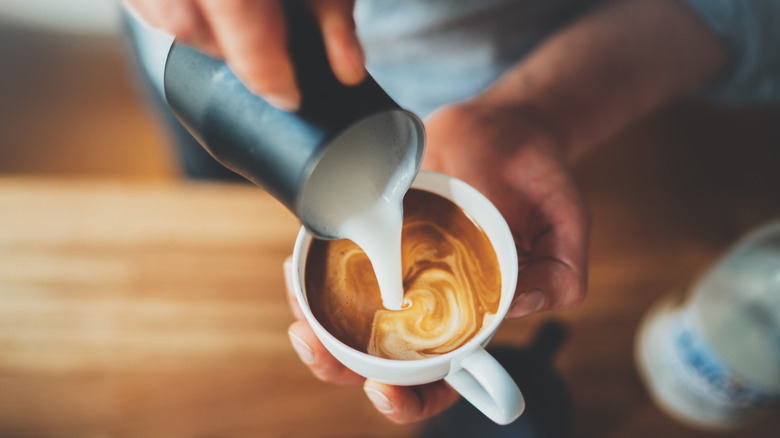 Milk being poured into a coffee