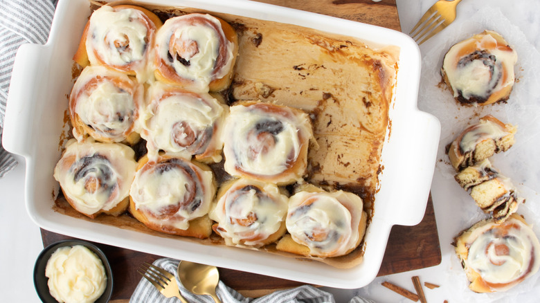 frosted cinnamon rolls in a white pan