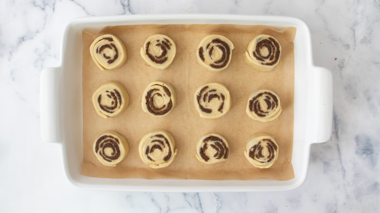 dough pinwheels in a white pan on a white countertop