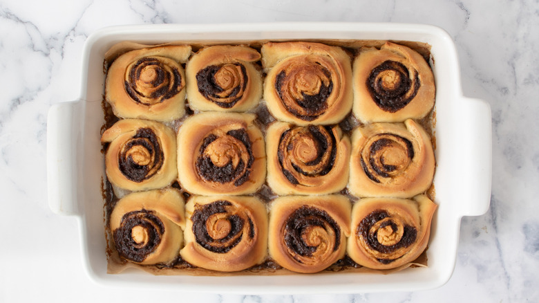 cinnamon rolls in a white pan on a white countertop