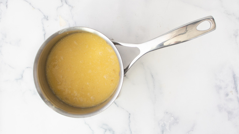 yellow liquid in a metal pot on a white countertop