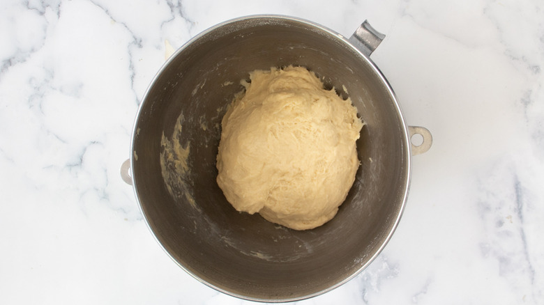 dough in a metal bowl on a white countertop