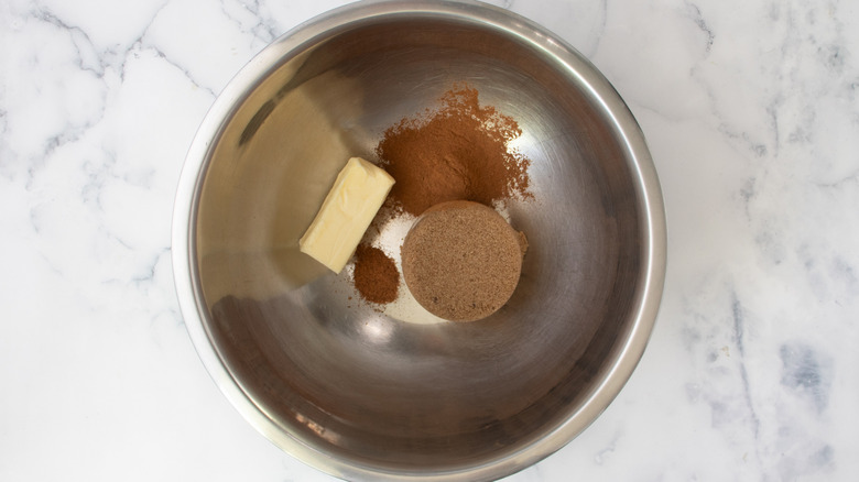 sugar, butter, and cinnamon in a metal bowl on a white countertop