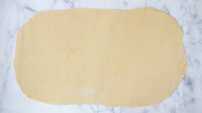 dough rolled into a rectangle on a white countertop