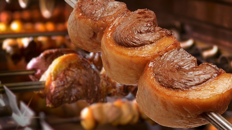 Picanha steaks above a rotisserie