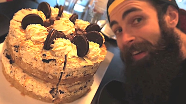 Adam Moran posing with a 10-pound cheesecake