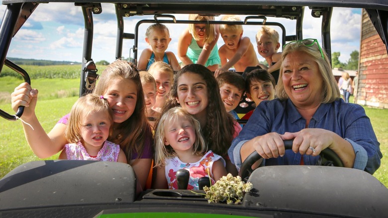 Nancy Fuller is surrounded by her grandchildren in an open-air vehicle