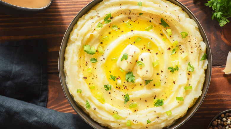 bowl of mashed potatoes with seasoning and butter