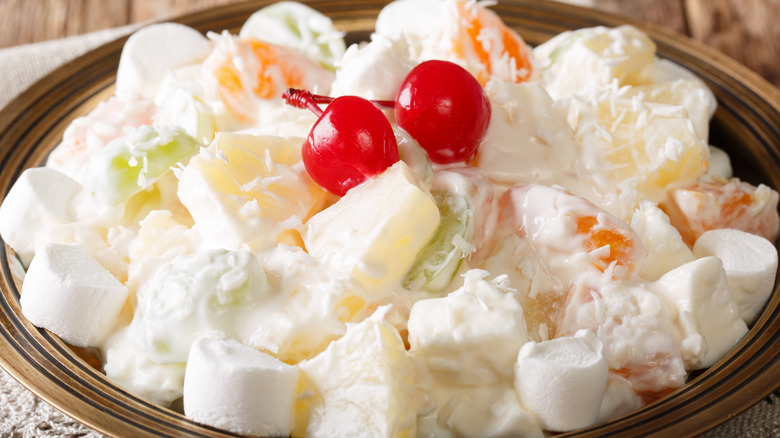 A dish of ambrosia salad with a red cherry