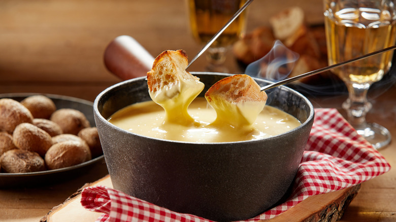 Bread being dipped into a fondue pot