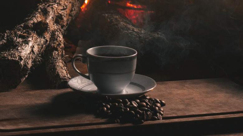 Cup of cowboy coffee by an open fire