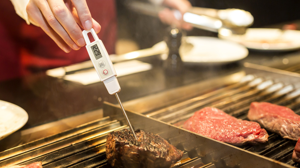 chef checking steak temperature 