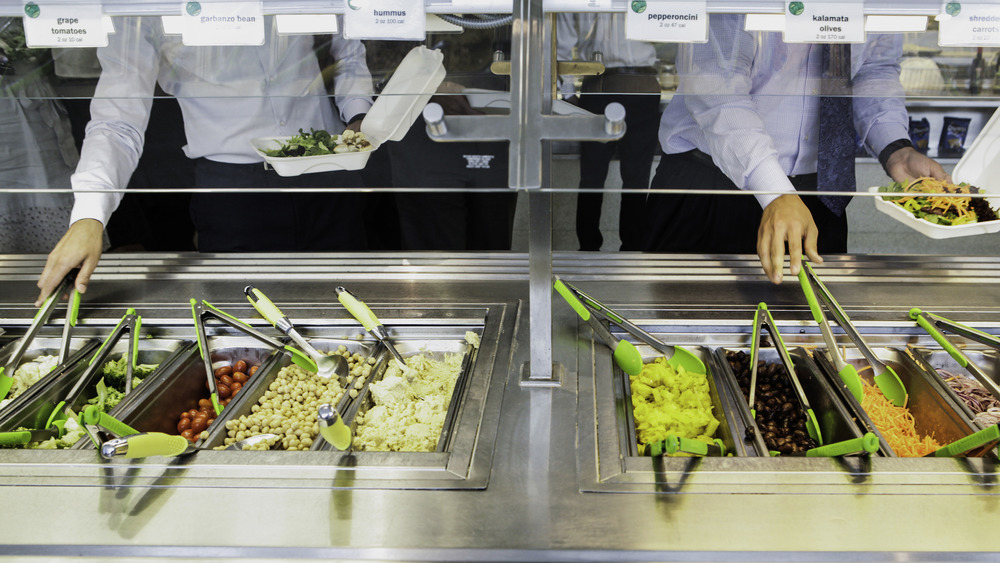 people getting food from a salad bar