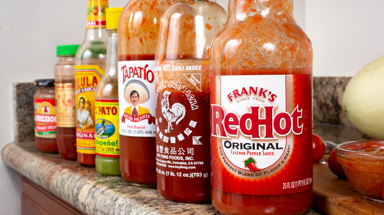 Bottles of hot suaces including Frank's, Sriracha, and Tapatio