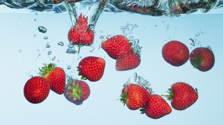 Strawberries falling to water