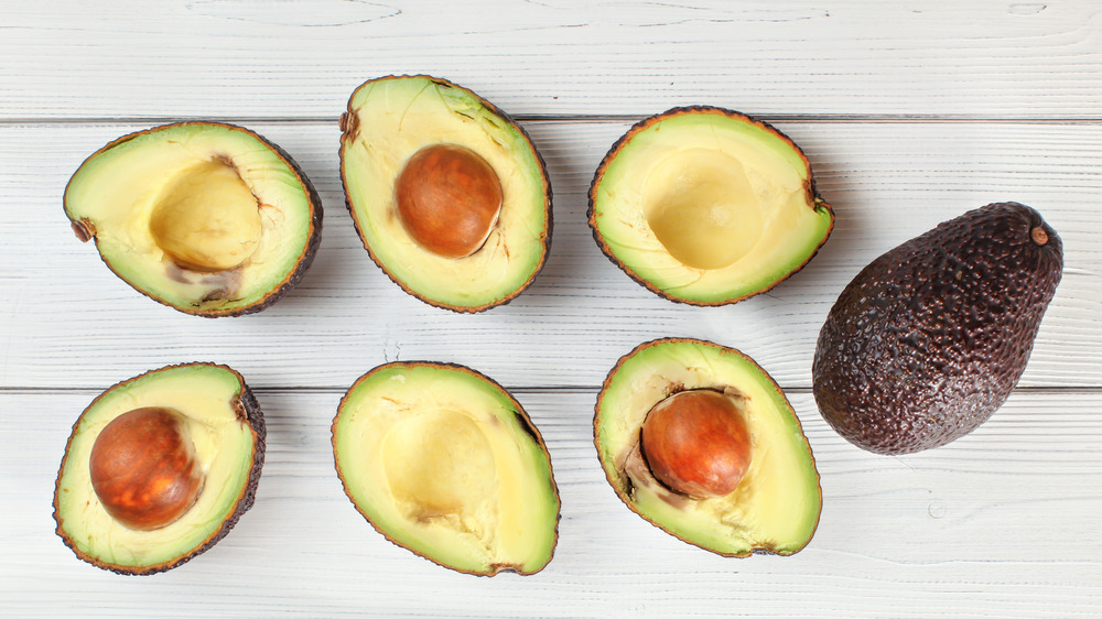 Avocados on white wood surface