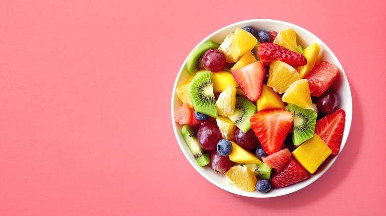 Bowl of fruit salad on pink counter