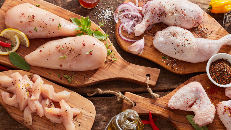 Seasoned raw chicken on wooden boards