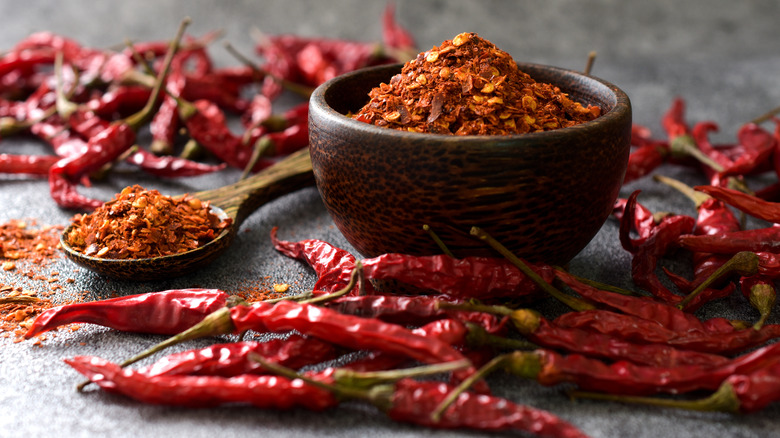 Crushed chili peppers in a wooden bowl and spoon