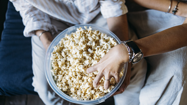 two people sharing popcorn 